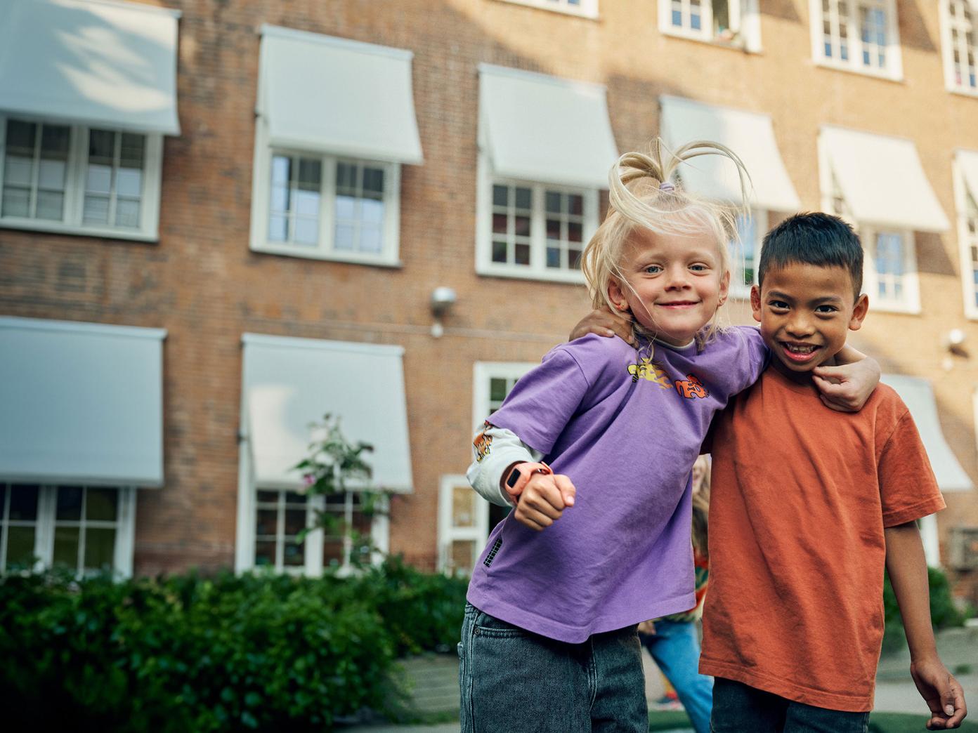 to børn holder hinanden om halsen