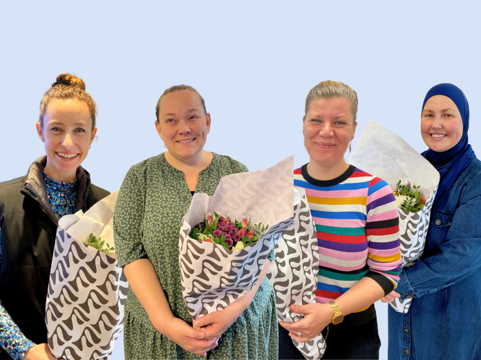 Fire kvinder på række med blomster