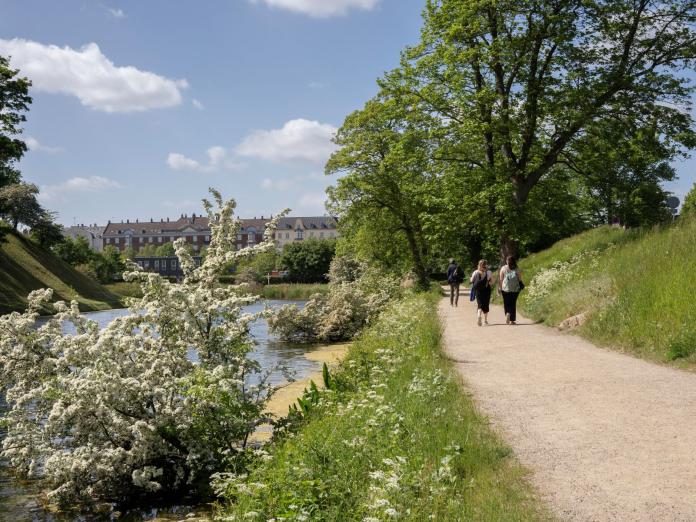 Mennesker går tur på grusstien omkring kastellet 