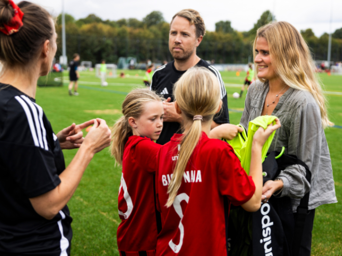 frivillige trænere og mor med vasketøj i fodboldklub