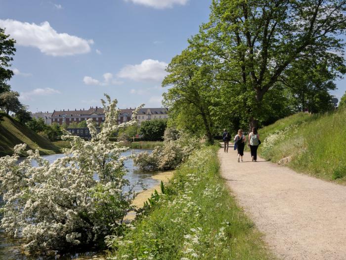 Mennesker går tur på grusstien omkring kastellet 